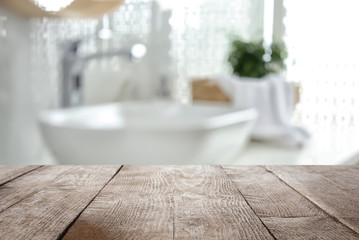 Empty wooden table and blurred view of stylish bathroom interior