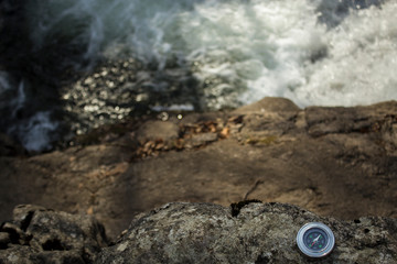 compass on a stone near the river