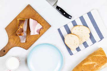 Flatlay above grey marble table with bacon knife and bread