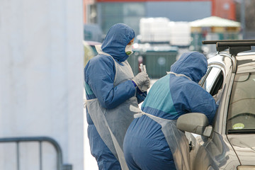 Coronavirus checkpoint. Medics with protective costumes take samples of blood for coronavirus (Covid-19)