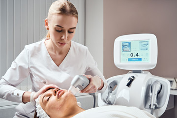 ultraformer lifting. Face Skin Care. Close-up Of Woman Getting Facial Hydro Microdermabrasion...