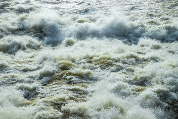 Fototapeta na wymiar Splashing water waves on the spring fast river