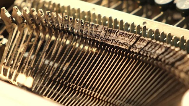 Mechanism of typesetting strikers with the English alphabet in an old retro typewriter.