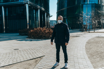  Man standing in the street with a medical mask. Coronavirus concept