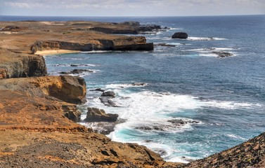 Waves crash against the flat shoreline on the islet of Dkeu in Cabo Verde