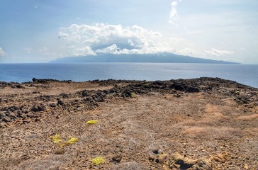 Dry terrain in Djeu with the island of Brava in the horizon under a thick cloudscape