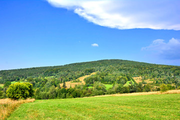 Beautiful summer landscape in the mountains with green meadows and forested hills, Low Beskids (Beskid Niski), Poland 