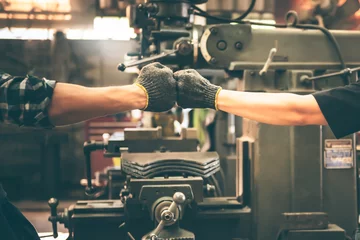 Fotobehang Experienced entrepreneurs, 2 engineers man Used hand for fist bump to show their cooperation For success teamwork, with blur soft of industrial machinery background, to people and synergy concept. © Anatta_Tan