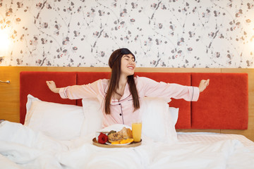 Obraz na płótnie Canvas Happy wife having breakfast with rose in bed