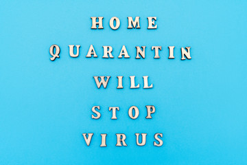 Slogan Home quarantine will stop virus made by wooden letters on pastel blue background. Coronavirus Pandemic Protection Concept. Minimal concept. Flat lay, top view