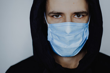 obligatory medical mask on everyone who leaves home during quarantine. Photo of a young man wearing a jacket and medical mask