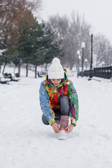 A young athletic girl ties her shoes on a frosty and snowy day. Fitness, running