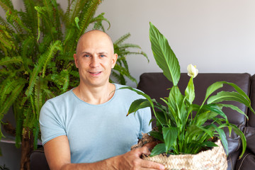 Fototapeta premium The man is pleased with the indoor plants grown by him.