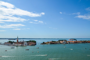 Venice, beautiful aerial view on San Giorgio Maggiore island in the Venetian Lagoon on a clear day. View from the San Marco Campanile. Ships and small boats surround the historic buildings.
