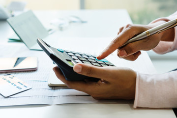 Young Asian woman Calculating monthy expense at her desk. Home saving concept. Financial and...