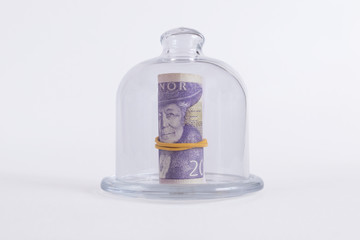 Money in a roll on a dish with a glass lid