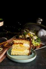 Delicious cake in the cut, a piece of cake with a layer of mango, passion fruit, vanilla cream, biscuit.