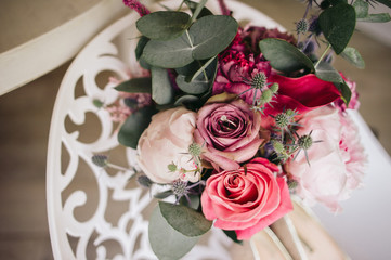 Beautiful wedding flowers with hidden engagement ring inside on a white chair
