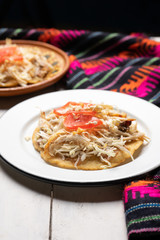 Mexican salbutes with shredded chicken on white background