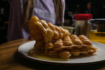  Waffles with honey on a wooden table