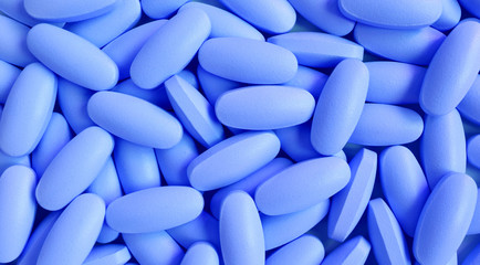 Heap of blue oval shaped pills for background and banner	