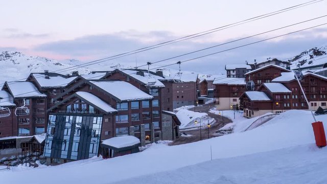 Timelapse of the morning in a snow village and ski lift starts running