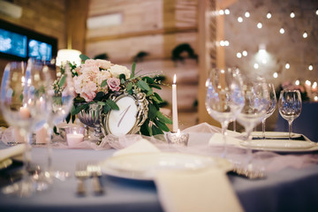 Wedding tablel elegantly decorated with tableware, flowers and candles