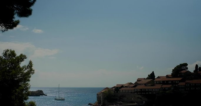 View through pine trees to the sea and  Sveti Stefan island in Montenegro