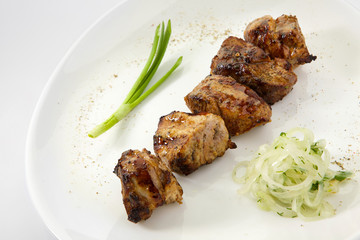 Appetizing stake with vegetables. Shish kebab isolated on white background