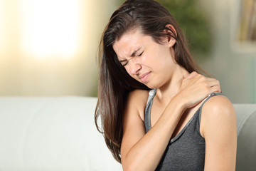 Girl complaining suffering shoulder ache at home