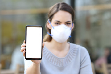 Woman with mask showing phone with blank screen
