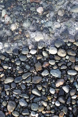 Multi shades of grey pebble with tidal waters and bubbles. 