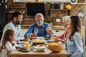 Happy senior man enjoying in family lunch at dining table.
