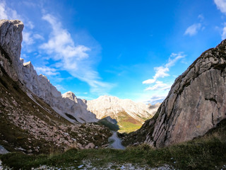 A pathway leading to high peaks in Italian Alps. Sharp slopes on both sides of the valley. Hard to...