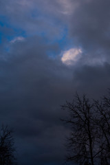 Naklejka na ściany i meble Thick gray clouds on a blue sky. Overcast weather.