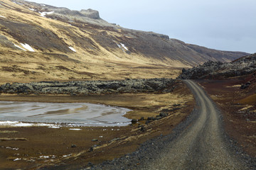 Fototapeta na wymiar Curved road between lava fields. Country road to nowhere
