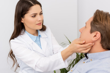 beautiful, attentive ent physician examining patient in clinic