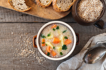 Krupnik, polish barley soup with vegetables on a wooden background