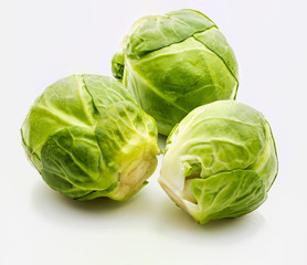 Fototapeta premium Close-up of raw, fresh and whole brussels sprouts (cabbages - Brassica oleracea). Isolated on white background.