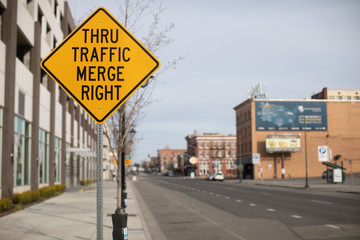Thru traffic merge right yellow traffic sign on city street