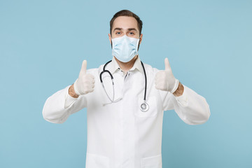 Male doctor man in white medical gown sterile face mask gloves isolated on blue background. Epidemic pandemic rapidly spreading coronavirus 2019-ncov sars covid-19 flu virus concept. Showing thumb up.