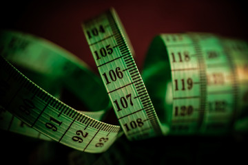 A swirled green tailoring meter use as a tool or instrument for measurements lengths, weights.