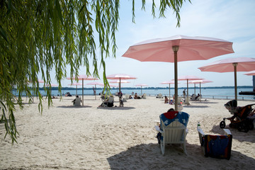 People sunbathing on the beach with beach umbrella