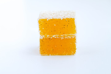 Pineapple, lemon, vanilla pate de fruit (jelly, marmalade, fruit candy) covered with sugar. White background, back view. There is a sliced jelly on a photo to show a texture inside of pate de fruit.