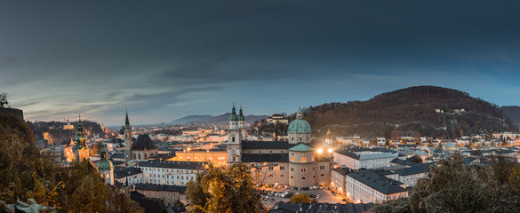 Panoramic view of the historic city of Salzburg with Salzburg Cathedral viewed from famous Festung Hohensalzburg illuminated in beautiful twilight during Christmas time in late autumn, Salzburger Land