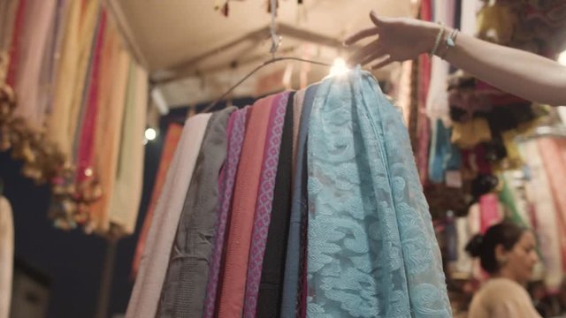 Close-Up on different clothes hanging on a coat hook on indian textile market