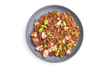 Quinoa porridge with green pea and chicken on ceramic plate isolated on white background. Top view.