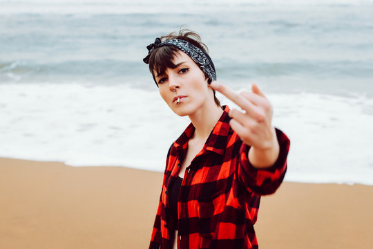 Woman showing middle finger on beach