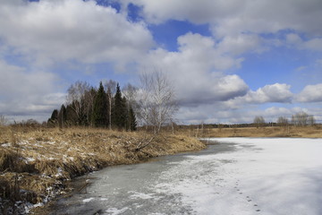 Landscape with small iced lake in sunny spring day