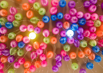 colorful neon color balloons hanging from ceiling 